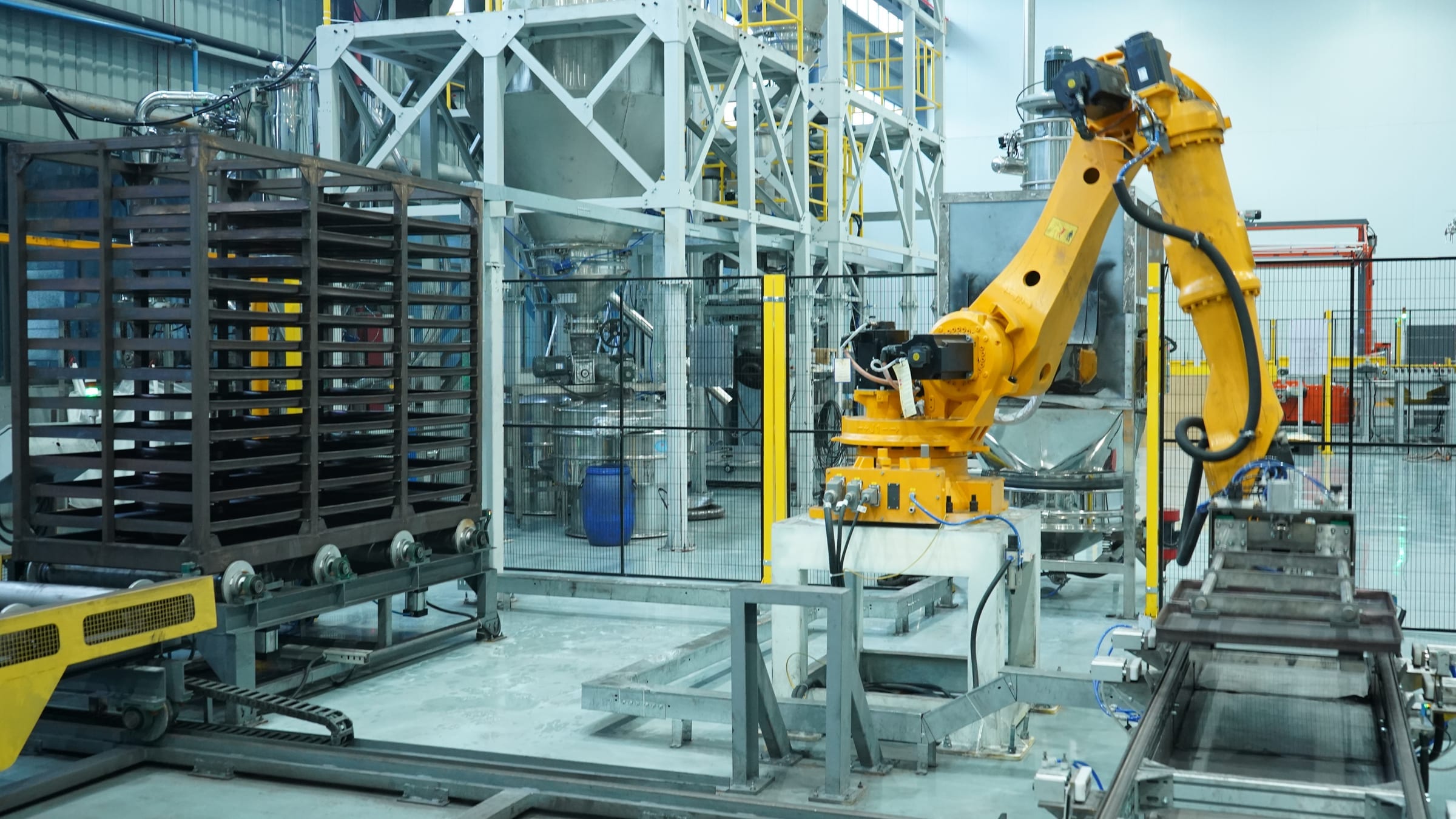Yellow industrial robotic arm integrated with conveyors and automated material handling.